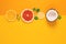 Composition of citrus fruit, orange, lemon and coconut on yellow background