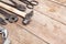 Composition of construction tools on an old battered wooden surface of tools: pliers, pipe wrench, screwdriver, hammer, metal shea