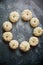 Composition of cute white Baby boo mini pumpkins placed in circle on dark stone table