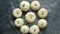 Composition of cute white Baby boo mini pumpkins placed in circle on dark stone table