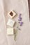 Composition of different handmade soaps and a mini lavender bouquet on a beige fabric background, natural spa cosmetics