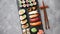 Composition of different kinds of sushi rolls placed on black stone board