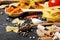 Composition of different varieties of pasta and cherry tomatoes, spices on a black background. top view. Place for text.