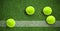 Composition of four tennis balls on grass tennis court with copy space