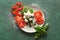 Composition with fresh basil, vegetables and mozzarella cheese on color textured background
