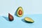 Composition of fresh fruits, salacca and two halfs of cutted avocado on two-colored background