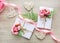Composition with gift boxes decorated with grin branch, rose, wooden hearts and satin pink ribbon
