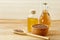 Composition of glass oil jars, wooden bowl and scoop with flax seeds, selective focus