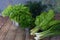 Composition of green herbs and vegetables. Organic spring mix for salad on brown wooden background. Onion, lettuce, parsley, leeks