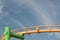 Composition with green and yellow painted carnival ride against a blue sky with wispy clouds, copy space