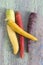 Composition with heritage carrot varieties against a rustic green wooden background