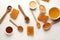 Composition with honey, spoons and honeycombs on white table