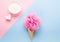 Composition of ice cream cone with pink wisp of bast on a light blue background