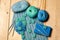 Composition of knitting tools and crocheted blue-green openwork napkins, balls of colored yarn, plastic grey hooks and book on