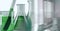 Composition of laboratory test tube and beakers with green liquid and copy space