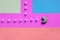 A composition of macaroon with an open mouth that is going to eat sugar cubes on a pink, lime, blue and coral background