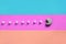 A composition of macaroon with an open mouth that is going to eat sugar cubes on a pink, lime, blue and coral background