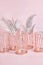 composition of metal candlesticks and palm leaves in rose gold on a pink background. modern home decor