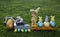 Composition of a model of an excavator, dump trucks, painted eggs, Easter bunnies standing on the grass