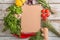 Composition with notebook, different fresh herbs and vegetables on wooden background