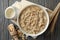 Composition oatmeal porridge on wooden background. Cooking breakfast
