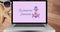 Composition of pink ribbon anchor logo and breast cancer text on the laptop screen