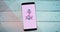 Composition of pink ribbon anchor logo on the smartphone screen