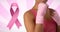 Composition of pink ribbon logo and breast cancer text, with woman guarding