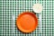 Composition with plastic dishware on checkered tablecloth