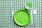 Composition with plastic dishware on checkered tablecloth