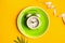 Composition with plate, alarm clock and measuring tape on a colored background. Diet concept and weight loss plan.