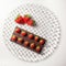 Composition of the plate with chocolate bar and strawberries on top and large strawberries on the side viewed from above