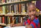 Composition of portrait of smiling african american schoolboy in library