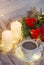 Composition: red roses with boxwood, garlands, candles, star and cup coffee