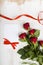 Composition of red roses, card and ribbon