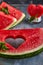 Composition with ripe watermelon, mint leaves and a heart carved in a slice of watermelon. Concept for valentines day