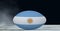 Composition of rugby ball decorated with the flag of argentina on black background