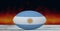 Composition of rugby ball decorated with the flag of argentina on black background