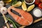 Composition salmon meat and spices on wooden background, top view