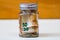 Composition with saving money banknotes in a glass jar. Concept of investing and keeping money, close up isolated