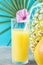 Composition of Tall Glass with Freshly Squeezed Tropical Fruit Juice with Straw and Flower Whole Pineapple Grapefruit