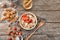 Composition with tasty oatmeal, strawberries and walnut on wooden background