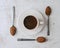 Composition of three spoons with ingredients enclosing a cup of Colombian chocolate