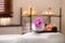 Composition with towel, candles and oils on massage table in spa salon