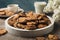 Composition with tray chocolate chip cookies on light brown table. Sweet breakfast