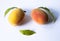 Composition of two peaches with leaves creating an image of a positive face