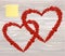 The composition of two red hearts. Valentine`s Day. Yellow sheet
