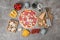 Composition with unbaked pizza and ingredients on table, top view