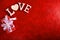 Composition for Valentine`s Day on a red background with white letters and a heart. Top view.