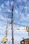 Composition of very tall power pole, traffic signals, and power lines before blue sky with light clouds